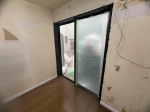 室内の窓枠とガラス引き戸の塗装前の状態。黒枠仕上げに向けて養生準備をしている場面。遮熱外壁専門店・山本。