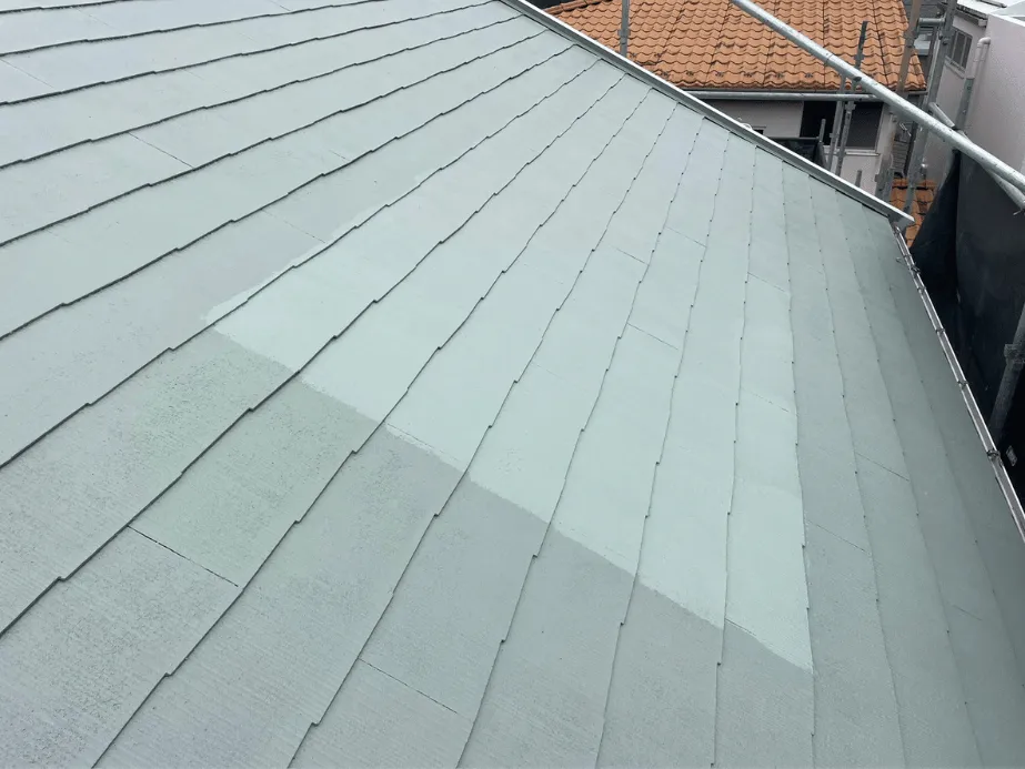 【施工レポート】屋根塗装で家を守る|遮熱塗料で夏の暑さ対策 4 遮熱塗料の中塗りを行う様子。明るいグレー系の塗料で、熱反射効果を高める。