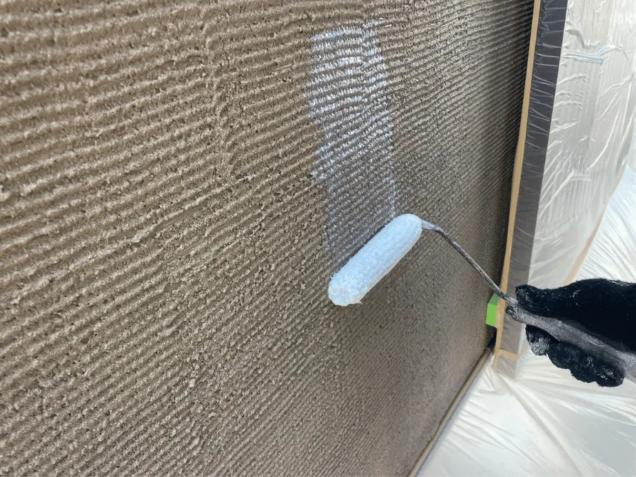 【施工レポート】外壁の下塗り|塗装の耐久性を決める最重要工程 2 茶系サイディング外壁に下塗り材をローラーでたっぷり塗布している施工中の様子