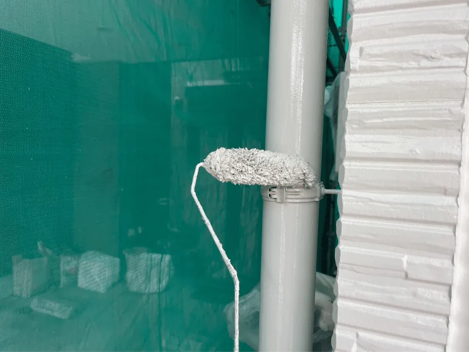 縦樋（たてどい）の塗装中の様子｜ローラーを使い丁寧にムラなく仕上げる工程